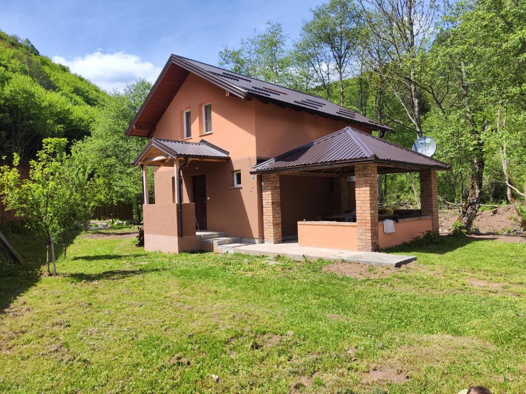 uma pequena casa com um alpendre num quintal em Villa Kaan em Trnovo