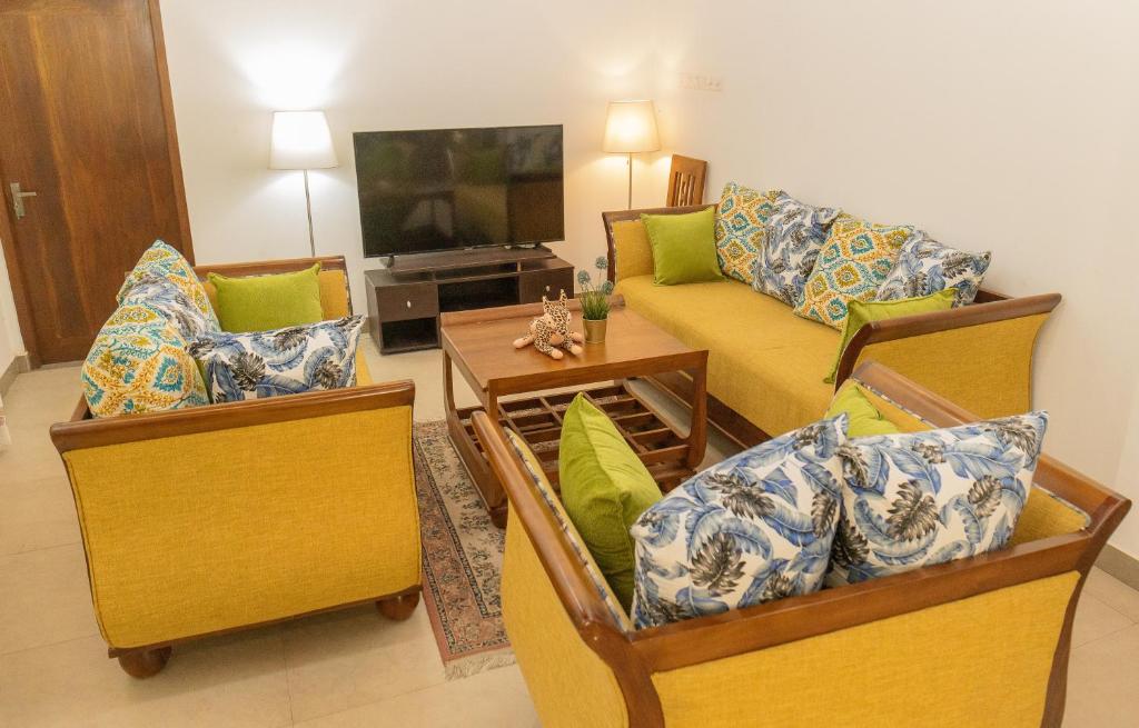 Villa Verde Alawwa في Alawwa: غرفة معيشة مع كرسيين وأريكة