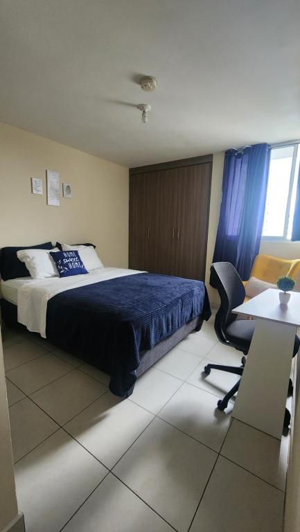 1 dormitorio con cama, escritorio y silla en Quédate con sulay habitación a 5mint del aeropuerto, en Ciudad Radial