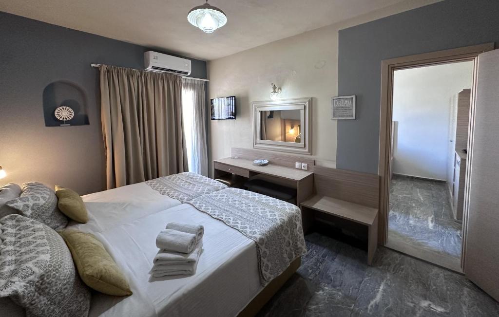 a bedroom with a bed and a desk and a mirror at Thalia deco City & Beach Hotel in Hersonissos