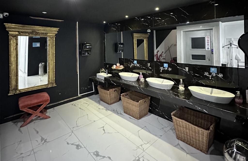 a bathroom with three sinks and two mirrors at Thalia deco City & Beach Hotel in Hersonissos