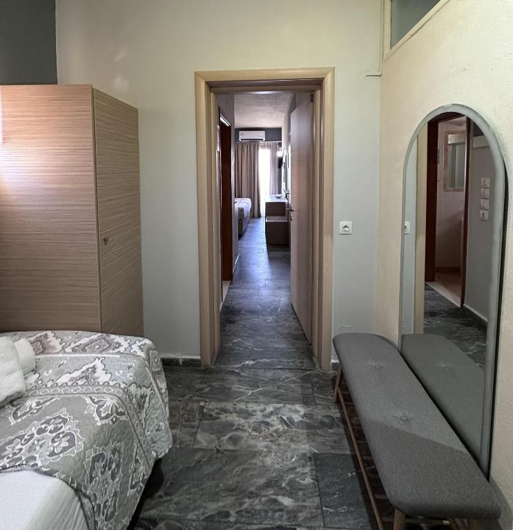 a corridor of a hotel room with a bed and a hallway at Thalia deco City & Beach Hotel in Hersonissos