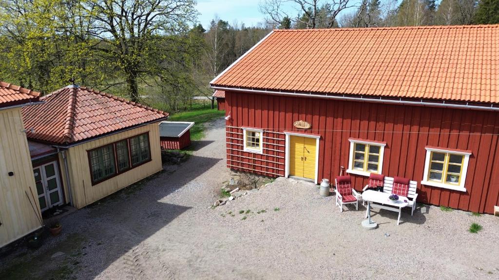 eine Aussicht auf ein rotes Haus mit einer Bank davor in der Unterkunft Stallet Boende utanför Alingsås in Alingsås