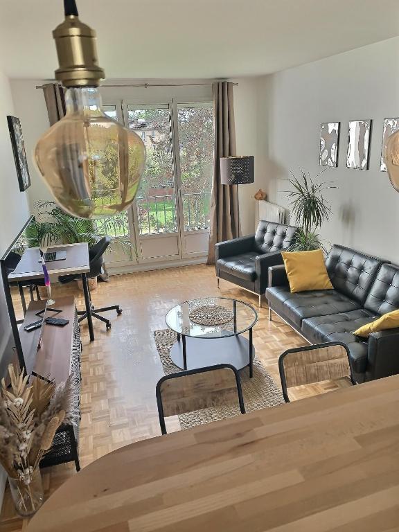 un salon avec un canapé et une table dans l'établissement Appartement cosy Thiais - Proche Paris et Orly Aéroport, à Thiais