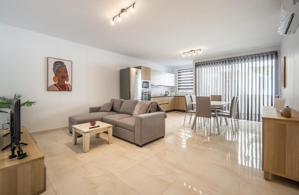 un soggiorno con divano e tavolo di Modern & Bright Central Home Wi-Fi & A/C a Mellieħa