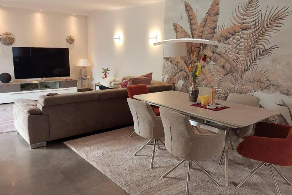 een woonkamer met een bank en een tafel met stoelen bij Superior Haus 120 qm mit Garten in Düsseldorf