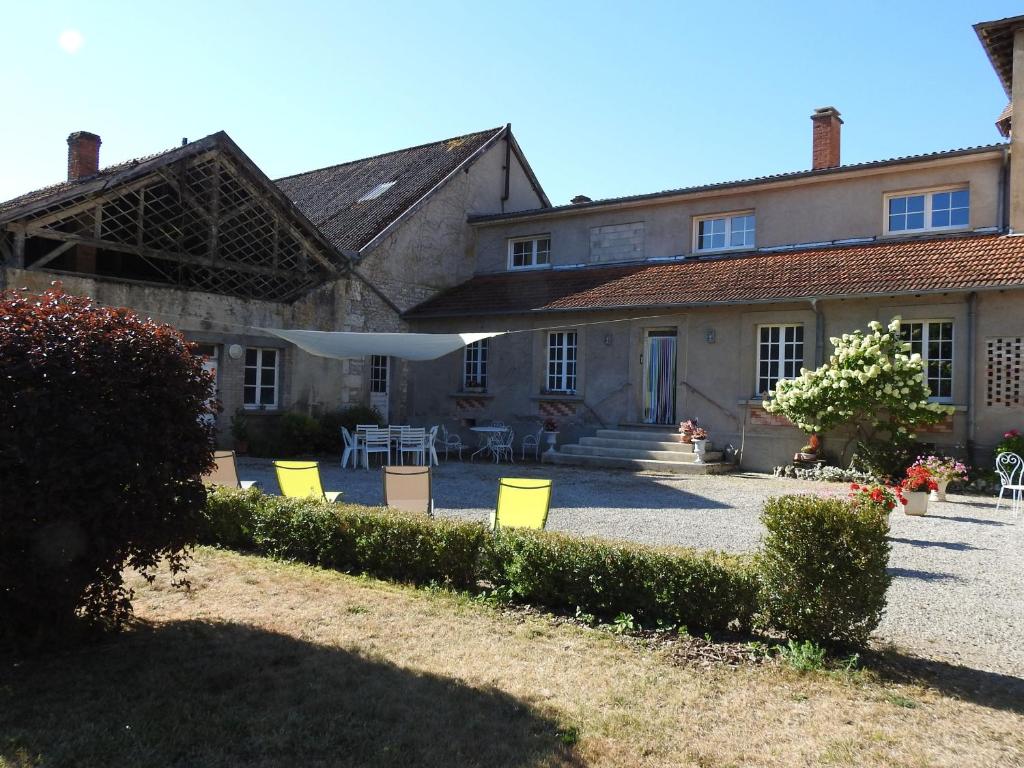 una casa con sillas amarillas delante de ella en Gîte tout inclus avec parc, proche de Joinville, pour 10 personnes et activités variées - FR-1-611-102, en Bettaincourt-sur-Rognon