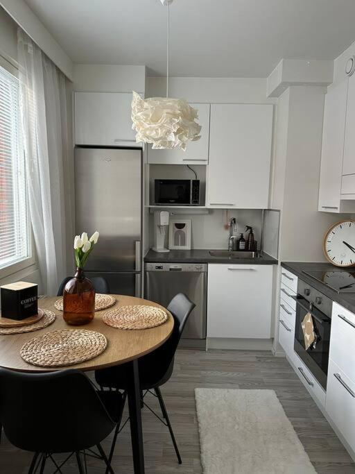 uma cozinha com uma mesa e cadeiras numa cozinha em Stunning city center studio with balcony 37 m2 em Lappeenranta