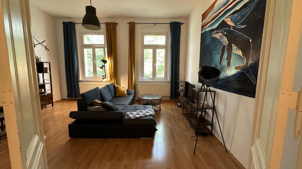 una sala de estar con sofá y una pintura en la pared en MiCasa TuCasa - Gemütliche und stilvolle 2-R Wohnung am Steintor, en Halle an der Saale