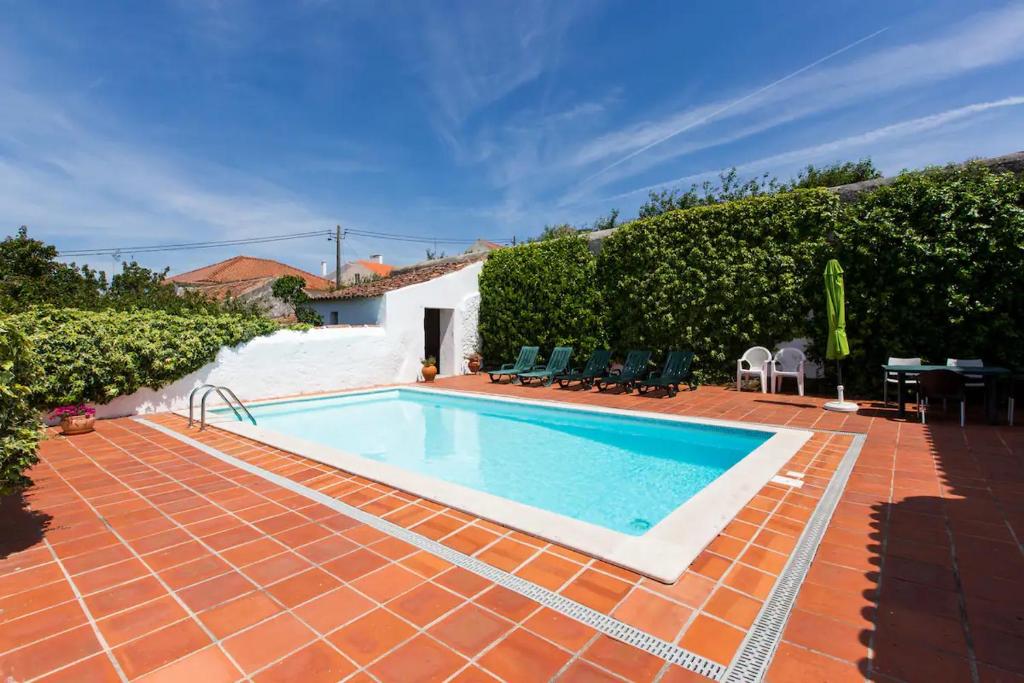 a swimming pool in a yard with a house at Vila Casa Do Sobral in Óbidos