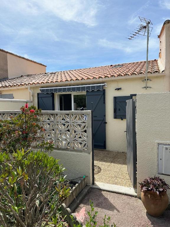 une maison avec un portail et une clôture dans l'établissement Maisonnette bord de Lagune et Plage St Cyprien, à Saint-Cyprien
