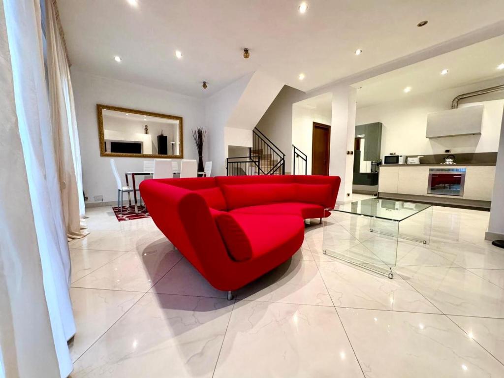 un sofá rojo en la sala de estar con cocina en Villa Gurrieri, en Roma
