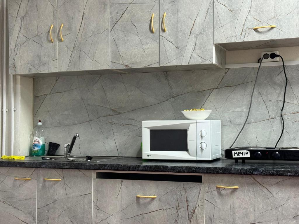 a microwave sitting on a counter in a kitchen at Хата - капсульный отель, хостел in Akbulak
