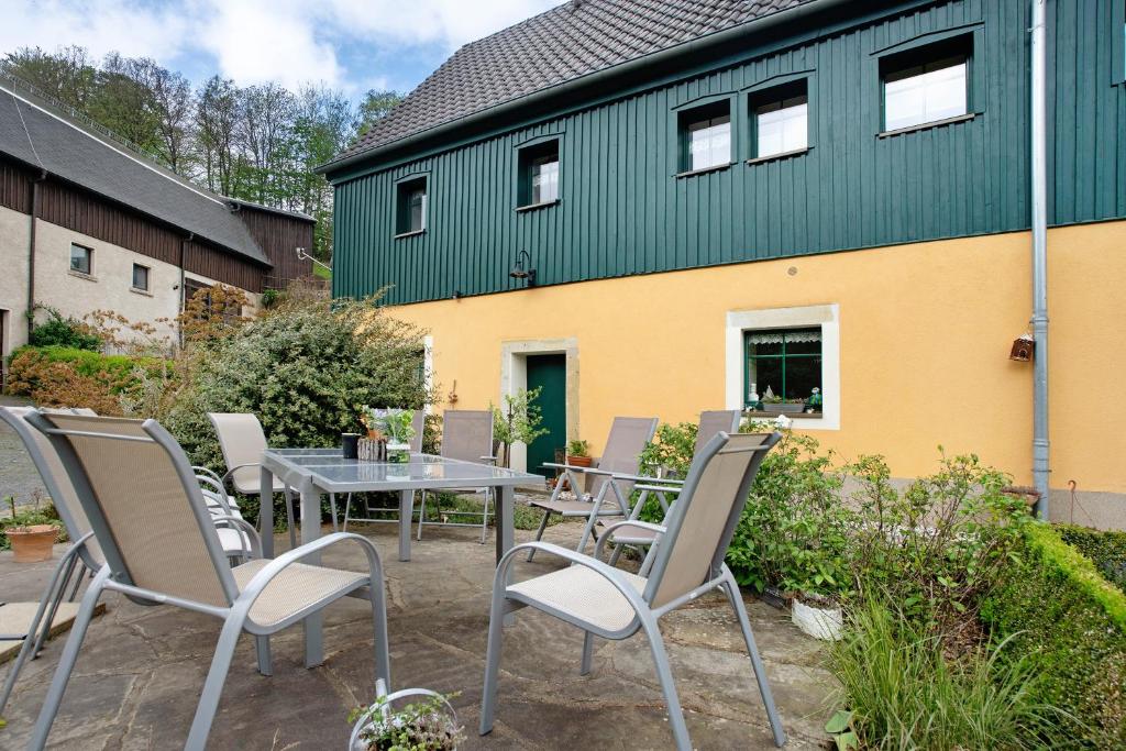 une terrasse avec une table et des chaises devant un bâtiment dans l'établissement Ferienwohnungen 'am Waldrand', à Hartmannsbach
