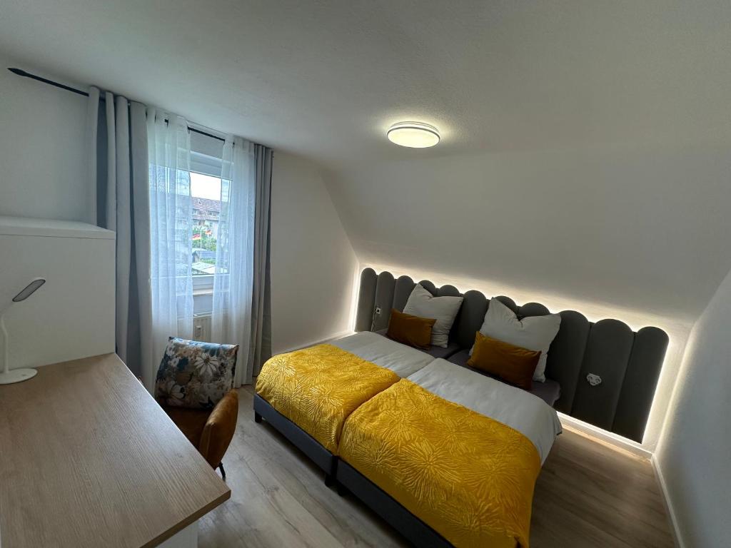 - une chambre avec un grand lit et une couverture jaune dans l'établissement Apartment- La Mia, à Castrop-Rauxel