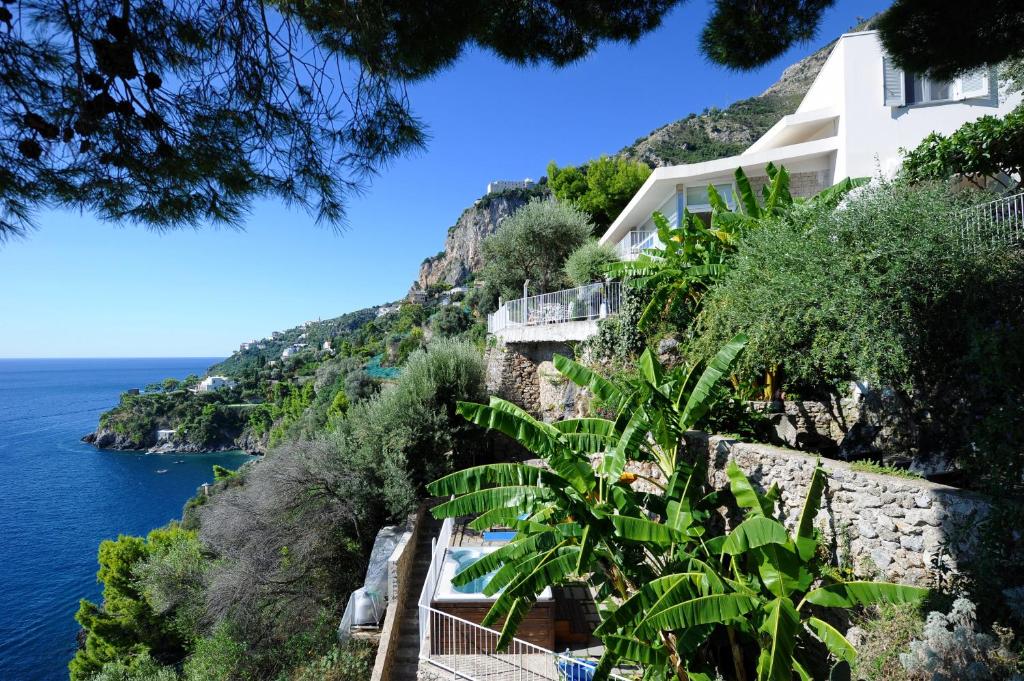 ein Gebäude auf einer Klippe am Meer in der Unterkunft Villa Santa Maria - Luxury Sea View Rooms in Amalfi