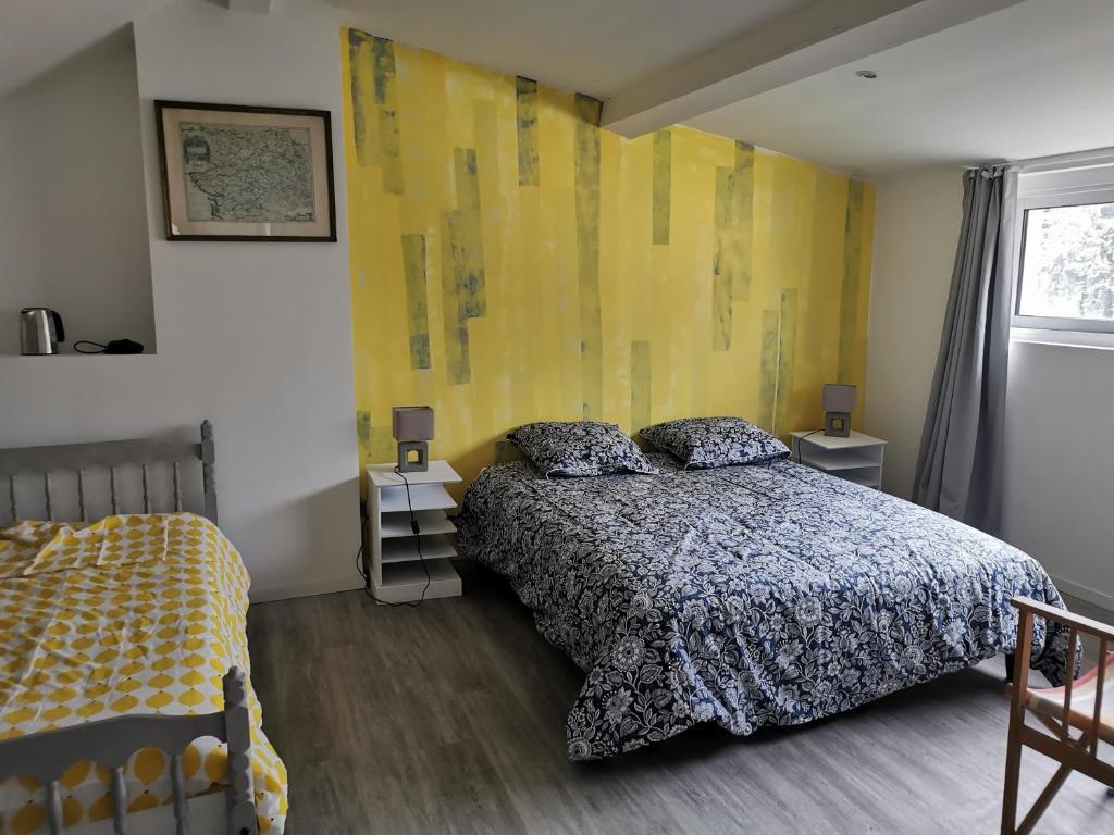 1 dormitorio con cama y pared amarilla en Bouvet Vincent, en Saint-Cyr-en-Val