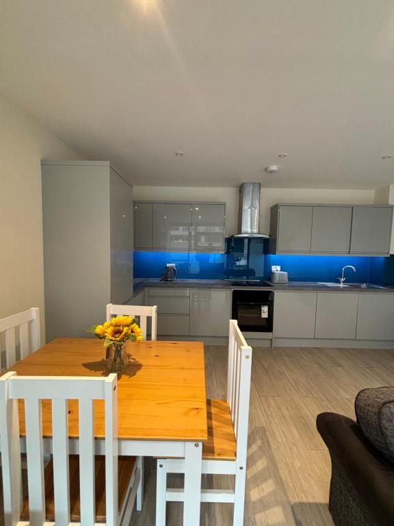 a kitchen with a wooden table and white cabinets at Claret and Blue Inn in London