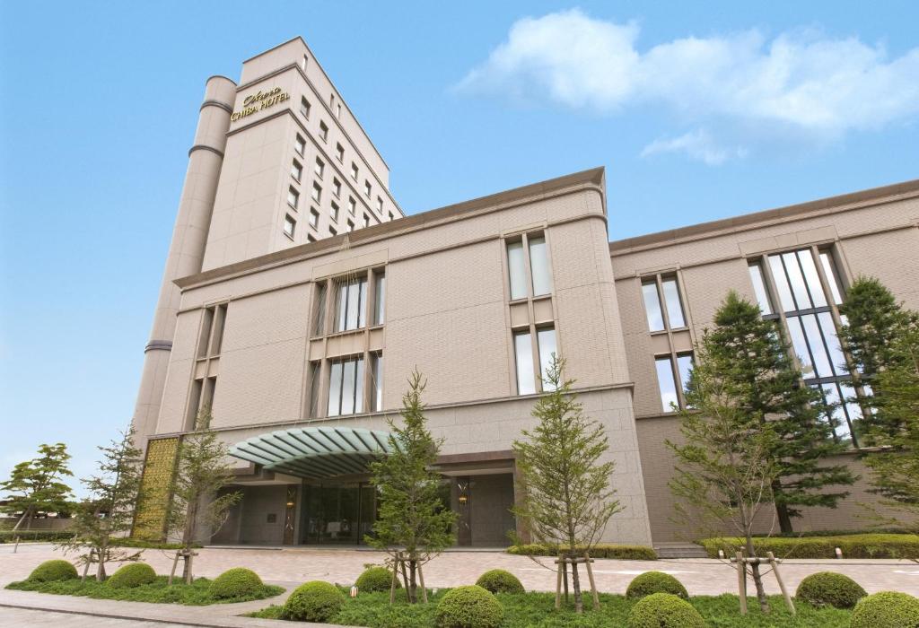 ein großes Gebäude mit Bäumen davor in der Unterkunft Okura Chiba Hotel in Chiba