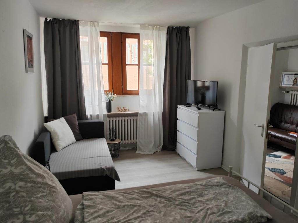 a bedroom with a bed and a couch and a television at Luitpold14 Prichsenstadt in Prichsenstadt