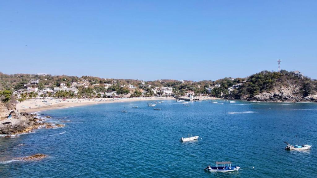 an aerial view of a beach with boats in the water at Casa Mamá Lolis in Puerto Ángel