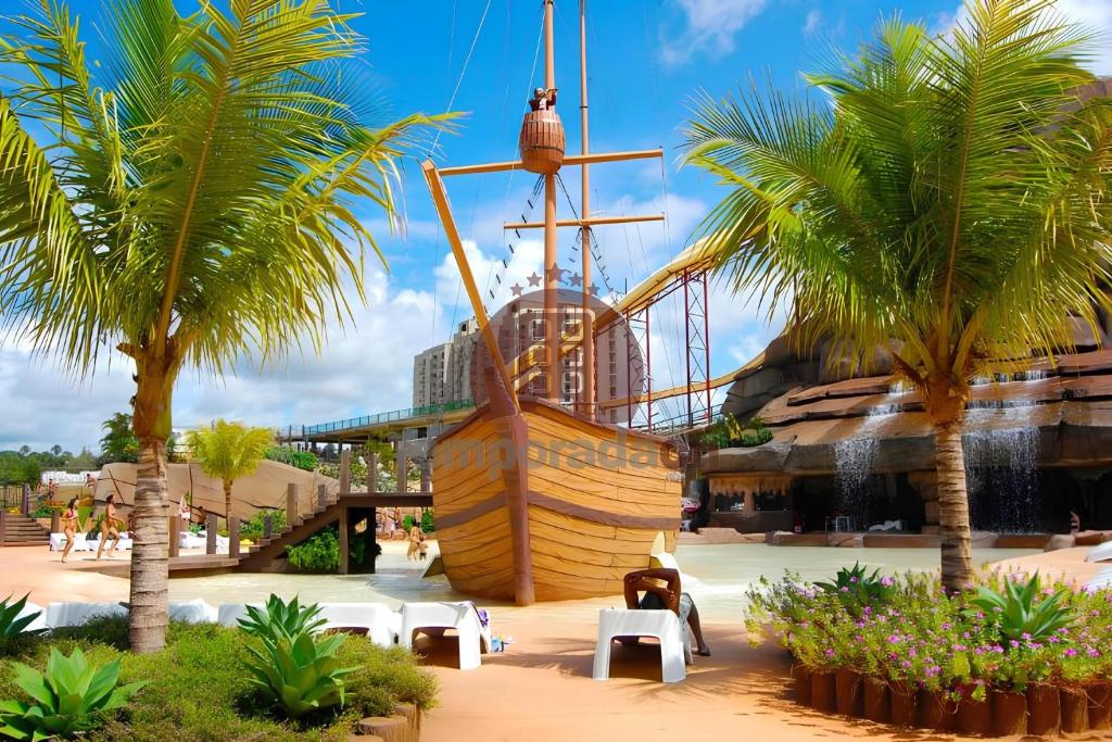 a pirate ship on the beach with palm trees at Spazzio diRoma com acesso ao Acqua Park - Gabriel in Caldas Novas