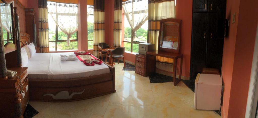 a bedroom with a bed in a room with windows at Despacito Hotel in Tanga