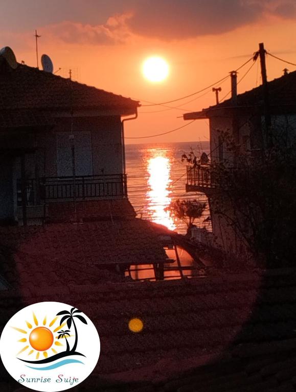 einen Sonnenuntergang über dem Meer mit der Sonne am Himmel in der Unterkunft Sunrise Suite in Olympiada