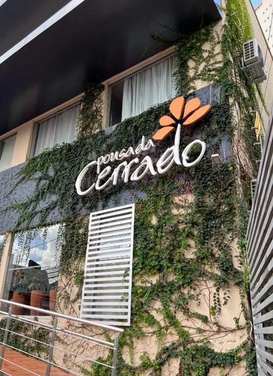 a sign on the side of a building with ivy at Pousada Cerrado in Goiânia