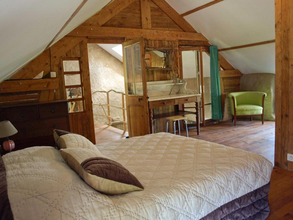 - une chambre mansardée avec un lit et un bureau dans l'établissement La Maison Cabane, à Saint-Martin-le-Hébert