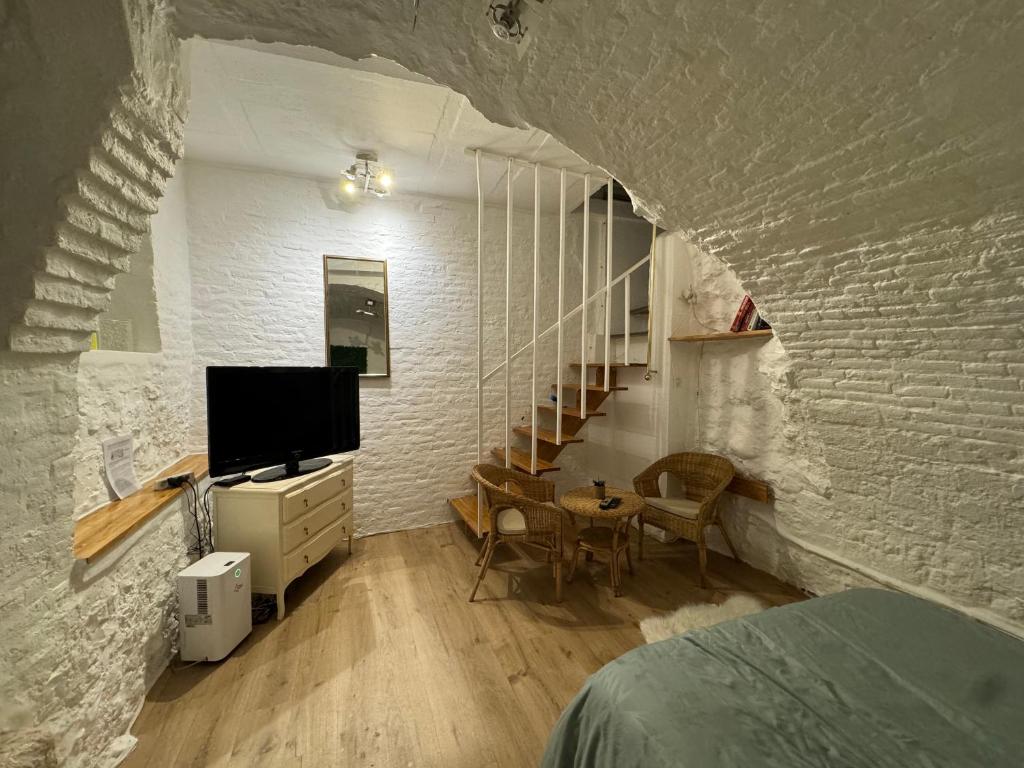 - une chambre avec un lit, une télévision et un escalier dans l'établissement « La Coquille Ancrée », à Dieppe