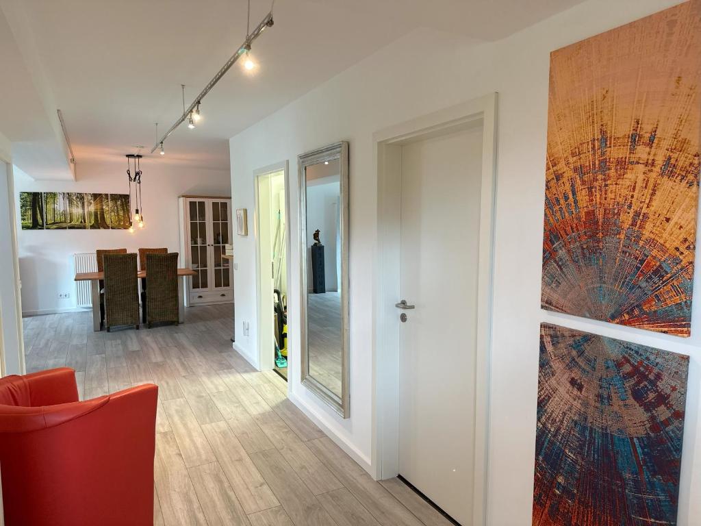 ein Wohnzimmer mit einem roten Stuhl und einem Gemälde an der Wand in der Unterkunft VennOase in Monschau