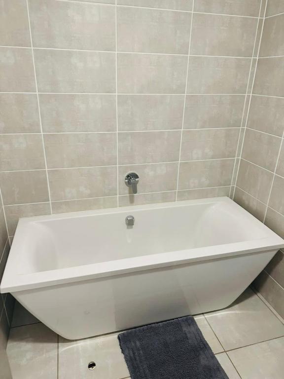 a white bath tub sitting in a bathroom at Napo Luxury stay in Pretoria