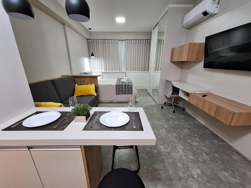 ein Wohnzimmer mit einem Tisch und einem Sofa in der Unterkunft Life 914B · LiNDO Estúdio no Lifespace Wifi Ar e TV Smart in Curitiba