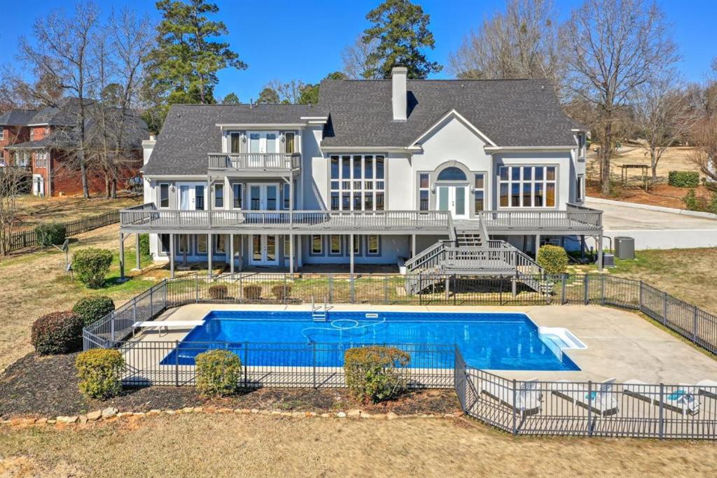 una casa grande con piscina frente a ella en Luxe Mansion w private lake and pool, en Evans