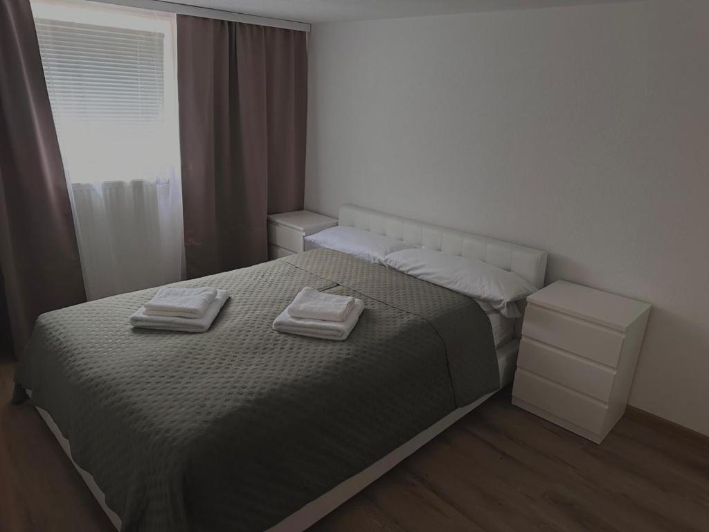 a bedroom with a bed with two towels on it at Comfortable 2 Bedroom Apartment Stuttgart &Ulm Area in Kuchen