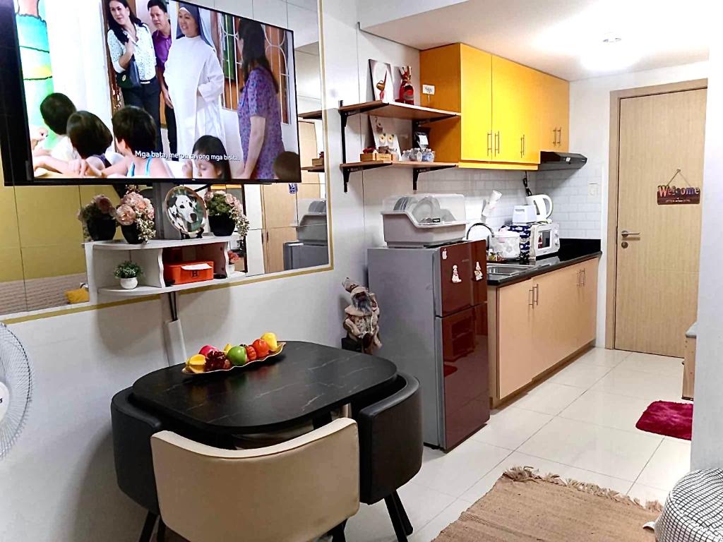 a kitchen with a small table in a kitchen at MyrVin at Grass Residences, QC in Manila