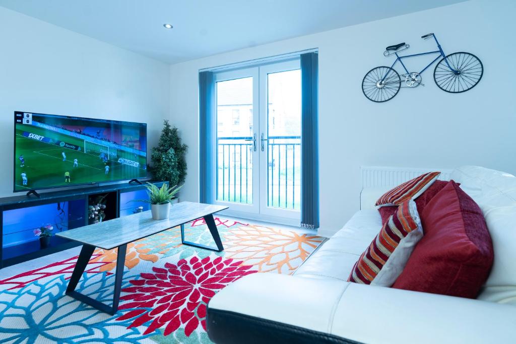 - un salon avec un canapé blanc et une télévision dans l'établissement Brand New Luxury Ground Floor 2 Bedroom Apartment free WiFi & Parking, à Sheffield