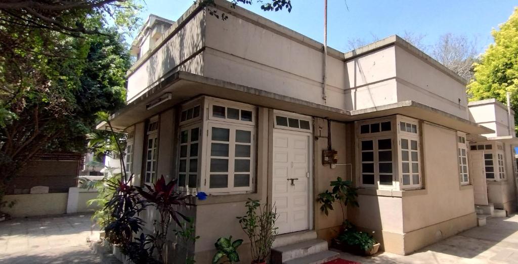 浦那的住宿－Madhav Bhavan Guest house，白色的房子,有白色车库