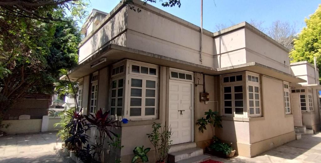 プネにあるMadhav Bhavan Guest houseの白いガレージ付白い家