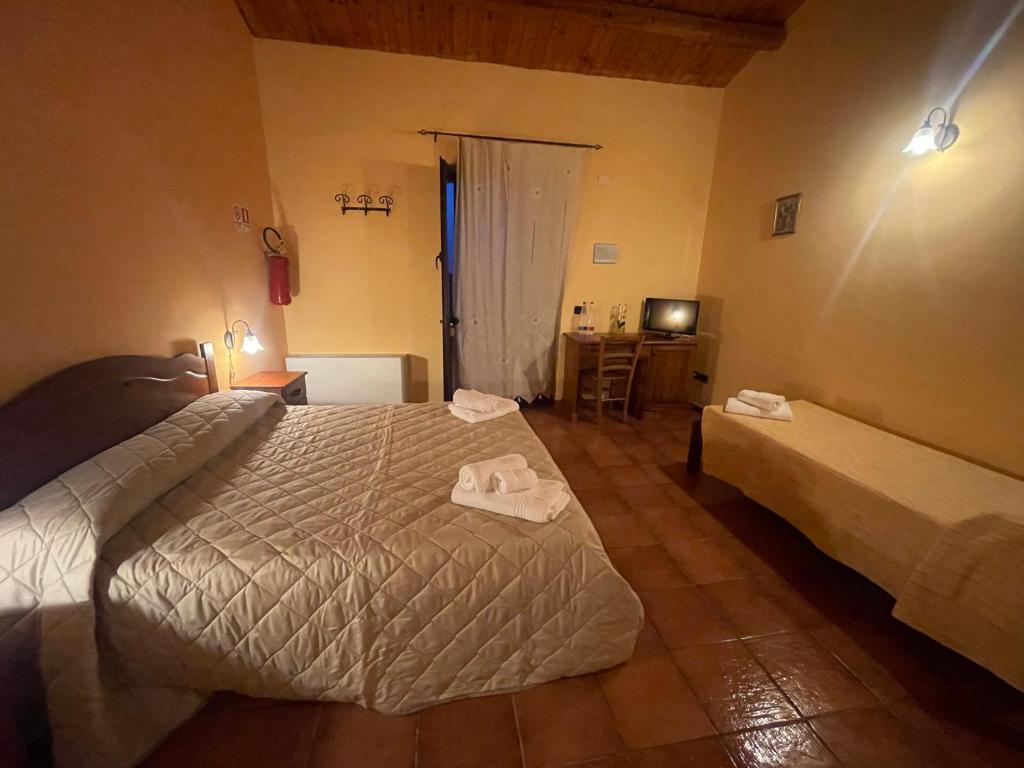 a bedroom with two beds and a desk and a television at Agriturismo Russa Belladonna in Caltagirone