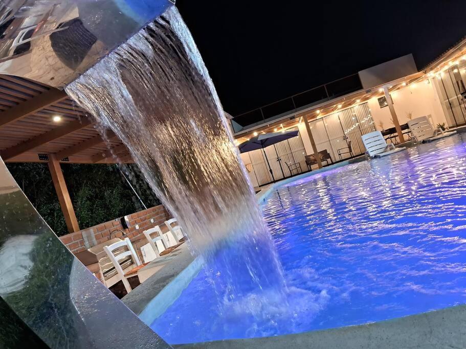 a water fountain in a swimming pool at night at Casa de Campo Villa Azul Cañete in Imperial