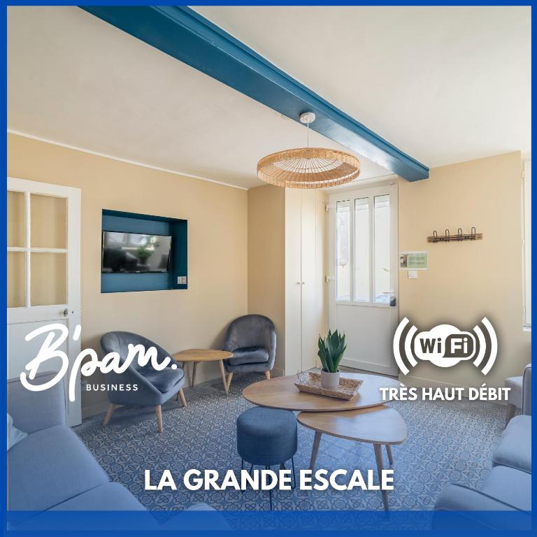 Cette chambre dispose de chaises, d'une table et d'une télévision. dans l'établissement La Grande Escale - Hyper Centre - Parking gratuit, à Trouville-sur-Mer