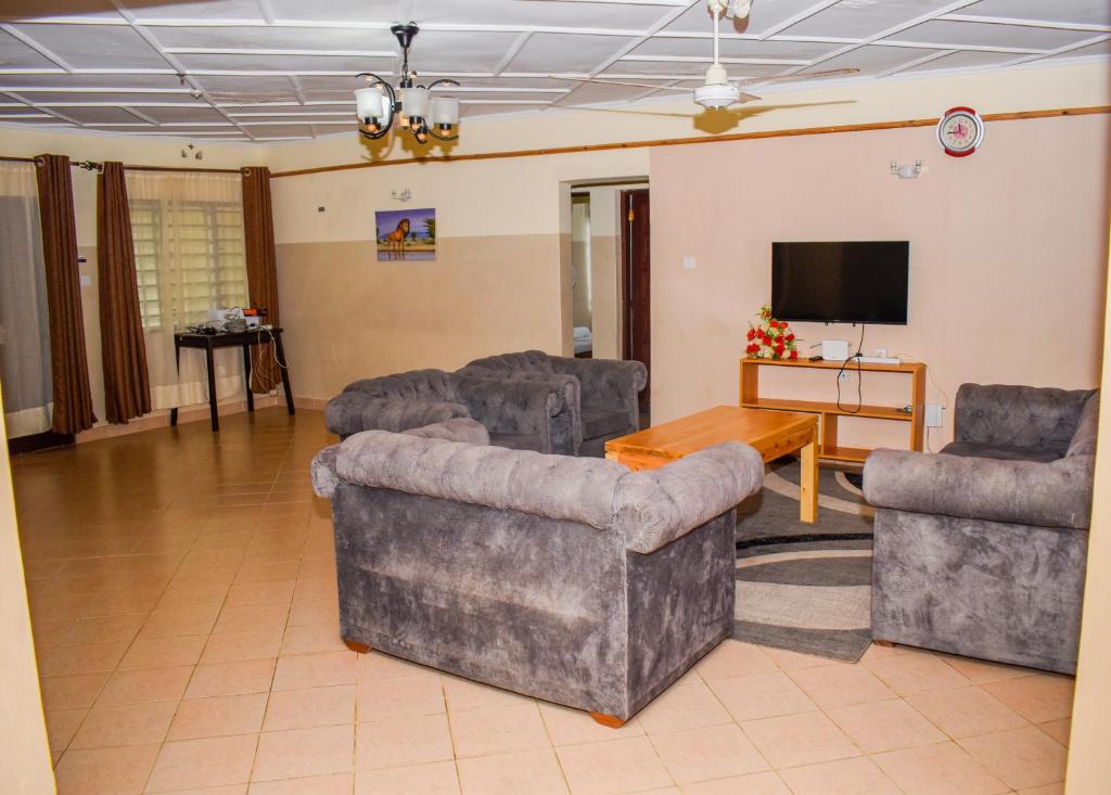 sala de estar con sofás y TV de pantalla plana. en Karura and friends airbnb (affordable), en Ukunda