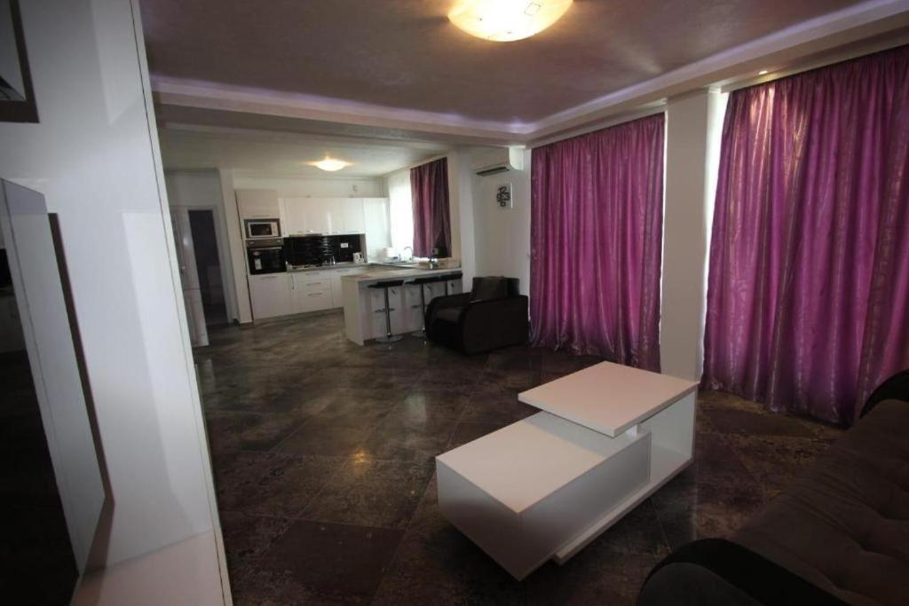 a living room with a couch and a table at Korallia Penthouse in Mamaia Nord