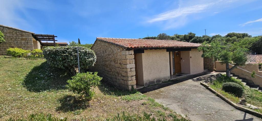 een klein huis in een veld naast een gebouw bij Caseddu T2 N 14, Alba Rossa avec Piscine Chauffée in Serra-di-Ferro