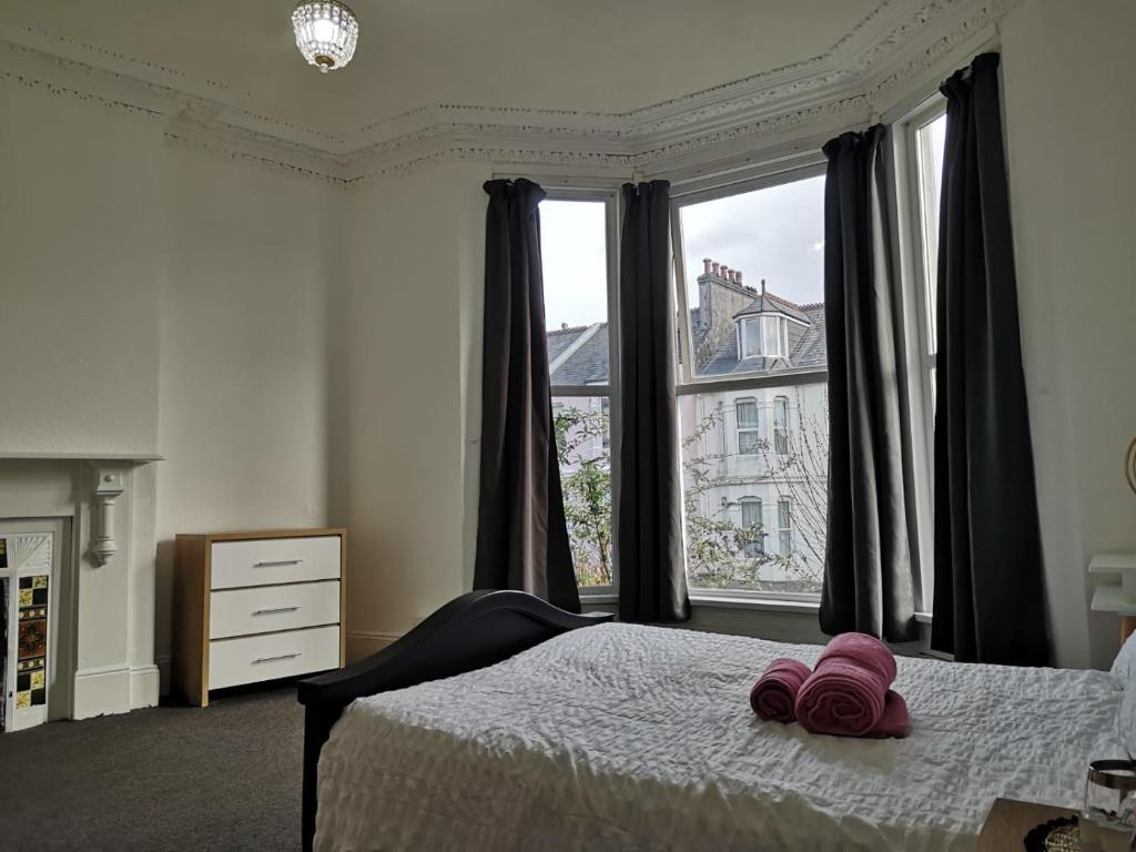 ein Schlafzimmer mit einem Bett und einem großen Fenster in der Unterkunft Freedom park villas room 1 in Plymouth