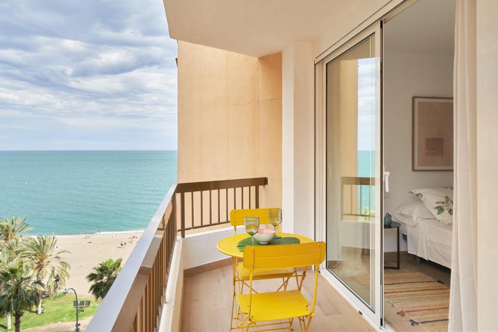 balkon ze stołem i krzesłami oraz oceanem w obiekcie Apartamento en primera linea de playa en la Malagueta w Maladze