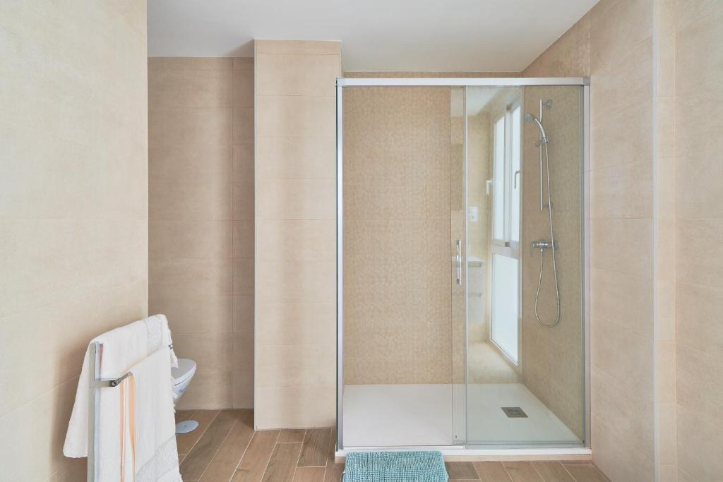 W łazience znajduje się prysznic ze szklanymi drzwiami. w obiekcie Apartamento en primera linea de playa en la Malagueta w Maladze