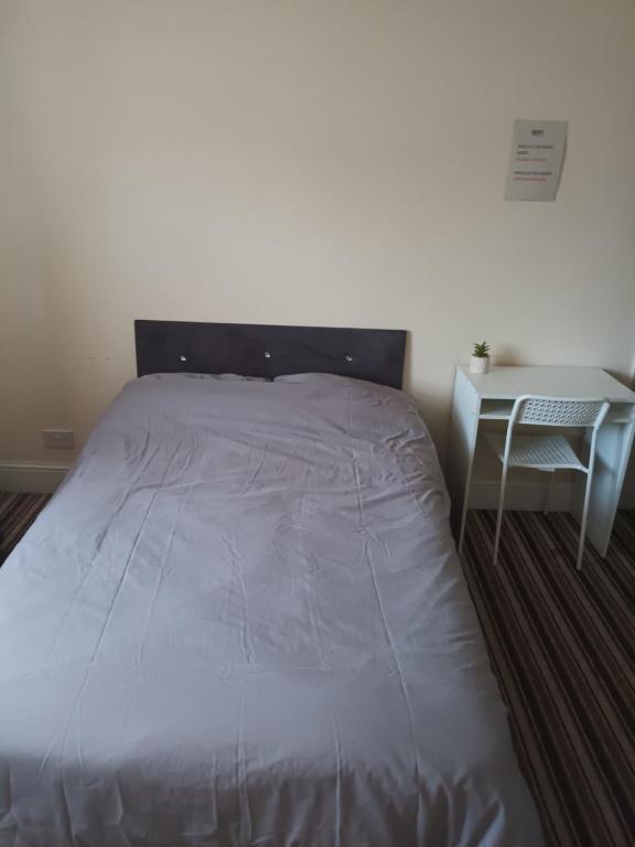 a bed in a room with a table and a bedskirtspectspectspectspects at Ansell road in London